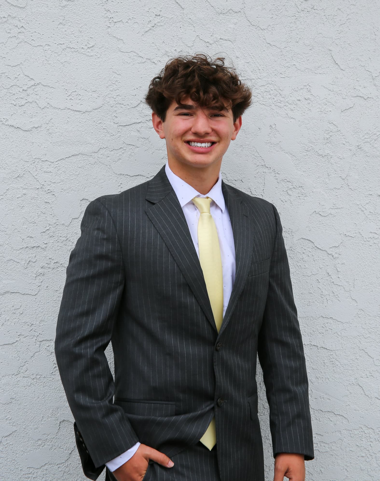 Maxwell Keller, standing, stucco wall